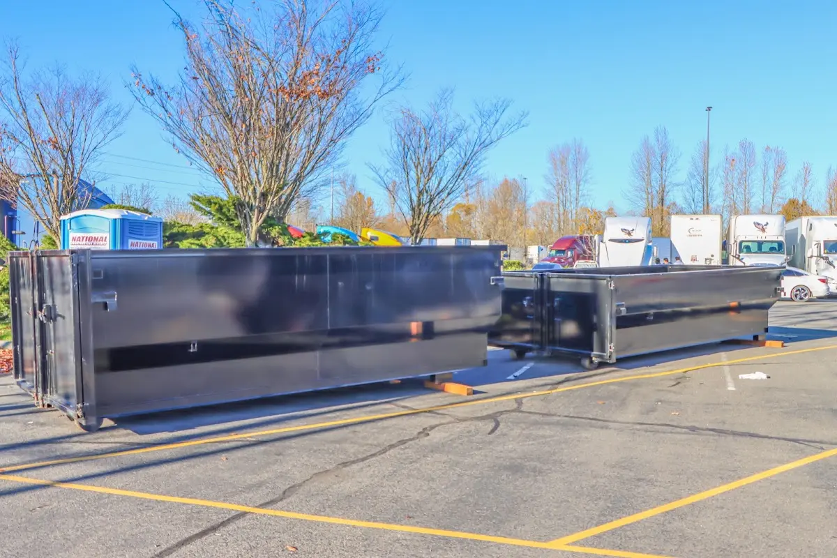 Professional dumpster rental service with roll-off container on residential driveway in Wood River